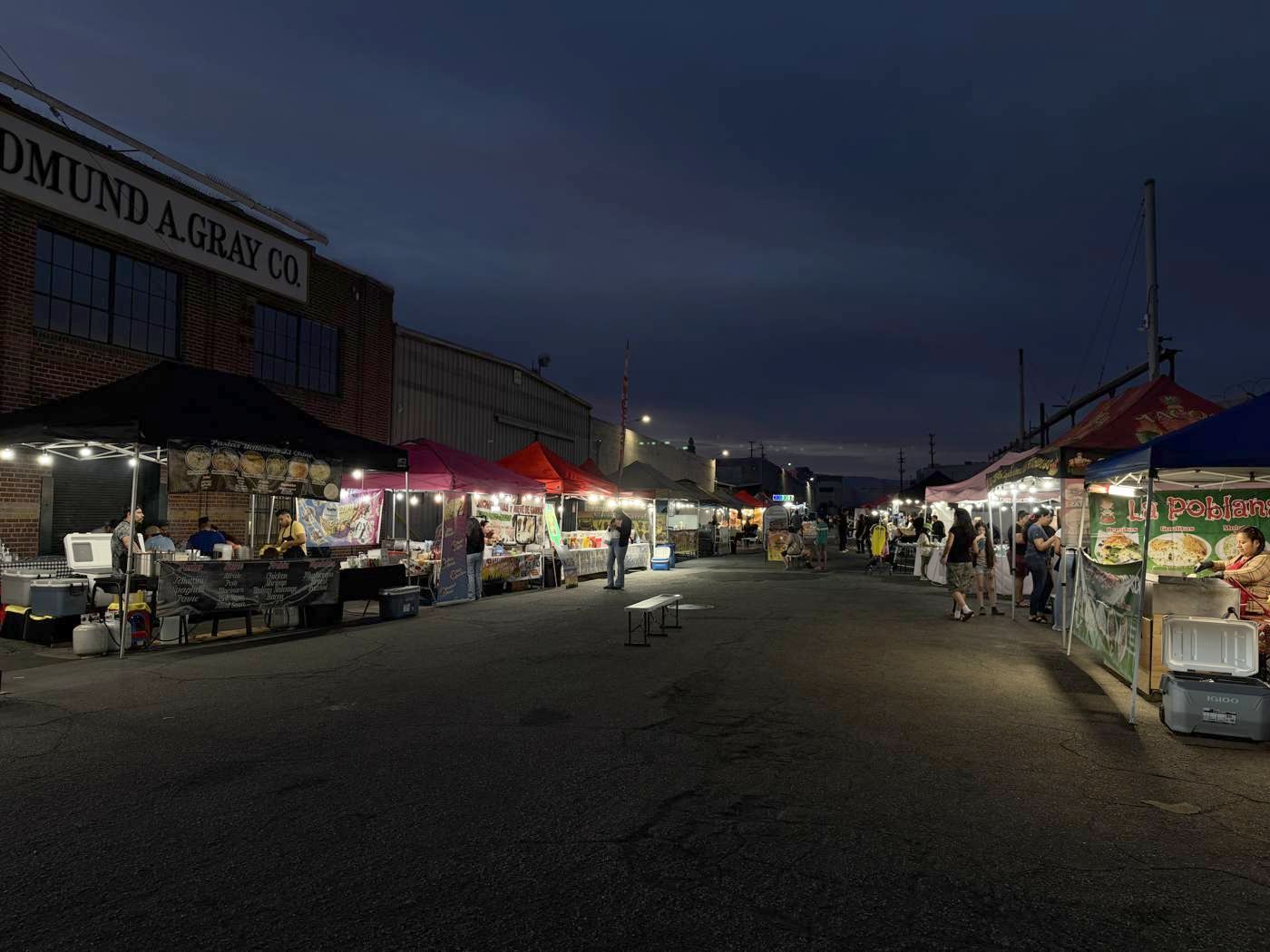 The market alley after dark with lit stalls on both sides