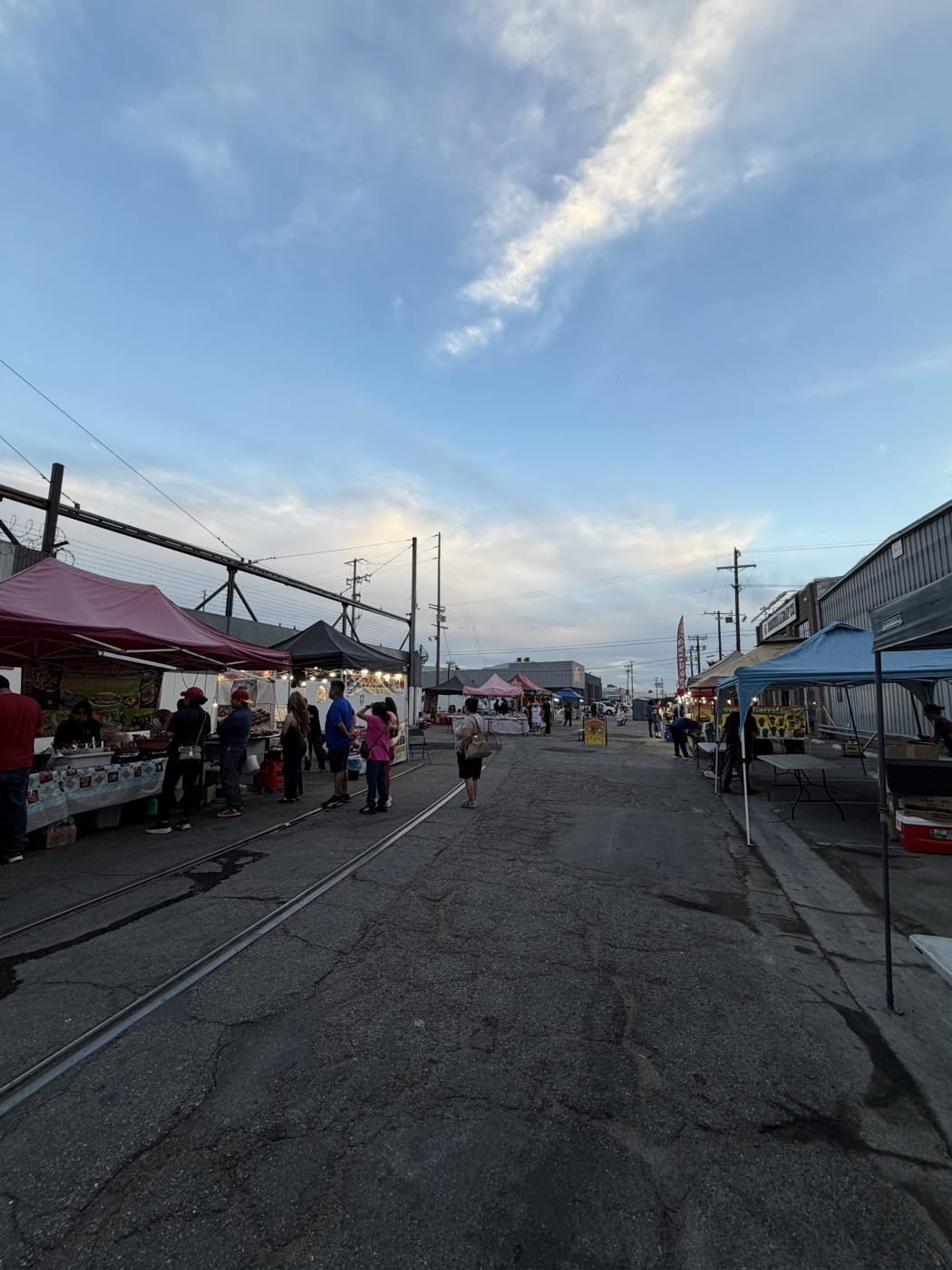 Stalls and string lights along the alley as dusk settles